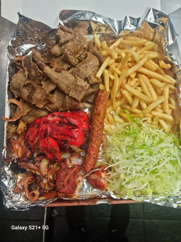 Doner, tandoori chicken, seekh kebab, chips and salad in a box