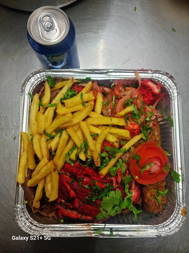 Mixed grill tray with chips, onions and a drink